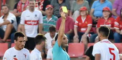 Un árabitro enseña una tarjeta amarilla a un jugador visitante, en el estadio del Nàstic, en una imagen de archivo de 2016