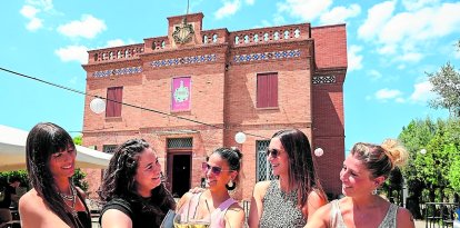 Un grupo de amigas brindan delante del Bar Restaurant Inèdit de Reus.