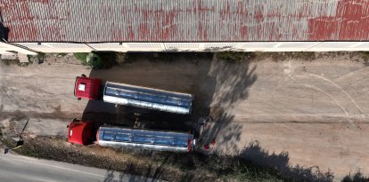 Dos camiones cisterna llenando agua de un depósito municipal