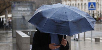 Un hombre se protege de la lluvia provocada por la borrasca Marta