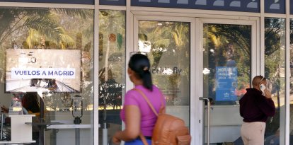 Personas caminan frente a oficinas de aerolíneas este lunes, en La Habana (Cuba). Cuba se queda sin combustible para aviones