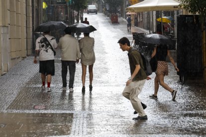 Imagen de archivo de varias personas refugiándose de la lluvia durante una tormenta de verano
