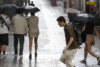 Imagen de archivo de varias personas refugiándose de la lluvia durante una tormenta de verano