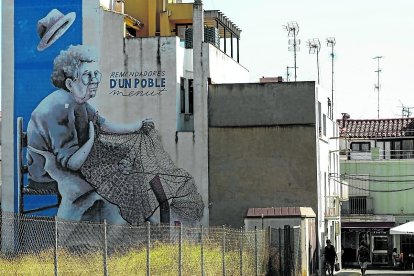 Mural urbà de l’artista local Lara Gombau dedicat a les dones ‘remendadores’, pintat a una de les parets de la plaça de l’Hort Adell, a les Cases