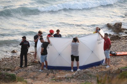 Gente que ha ayudado a salvar a los ahogados, servicios de emergencias y Mossos, en la playa Llarga.
