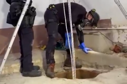 Los mossos inspeccionan la fosa séptica.