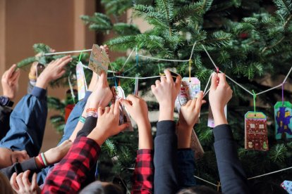 Los niños y niñas participantes dejando sus deseos en el árbol