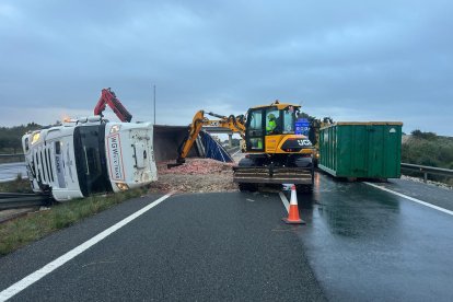 El camión ha quedado volcado y ha perdido la carga