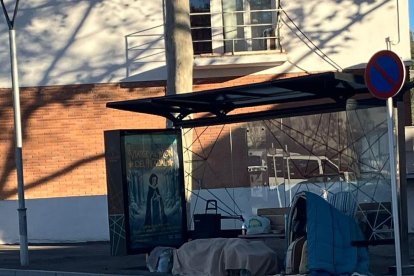 Mujer sin techo en una parada de bus de Calafell