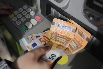 Imagen de archivo de una persona sacando dinero de un cajero automático.