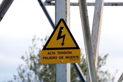 Cartel en el que se advierte del peligro de alta tensión en una de las torres eléctricas
