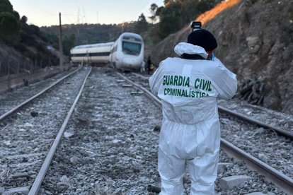 Un agente de la Guardia Civil toma fotografías para la búsqueda de evidencias que puedan servir para la identificación de víctimas e investigación del accidente