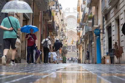 Varias personas pasean bajo la lluvia en la Part Alta de Tarragona