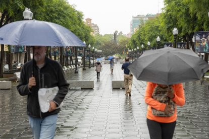 Imagen de varias personas paseando bajo la lluvia en Tarragona