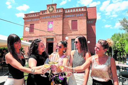 Un grupo de amigas brindan delante del Bar Restaurant Inèdit de Reus.