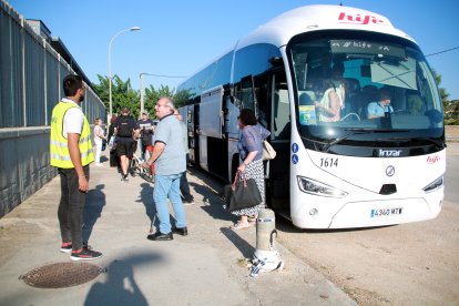 Pasajeros bajando de un autobús para continuar el trayecto desde la estación de tren de Cunit
