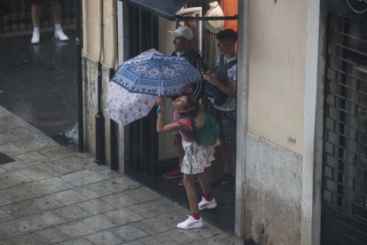Varias personas se protegen de la lluvia