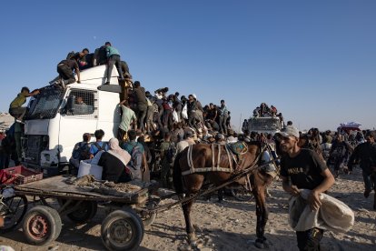Palestinos desplazados internos suben a camiones de ayuda humanitaria para conseguir comida cerca de un punto de distribución de alimentos en el corredor de Morag, al sur de Gaza.