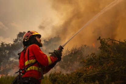 Un efectivo de la Unidad Militar de Emergencias (UME) en la localidad de A Espasa, durante el incendio forestal que permanece activo en Chandrexa de Queixa (Ourense), este martes.
