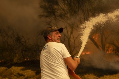 Vecinos de la aldea de Lamas (Cualedro) intentan aplacar el fuego que afecta este viernes esta zona de Ourense.