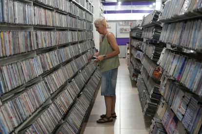 Una de las trabajadoras del Video Instan colocando algunas películas