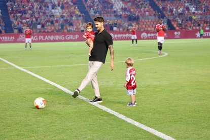 Joan Oriol realizando el saque de honor junto a sus dos hijos.