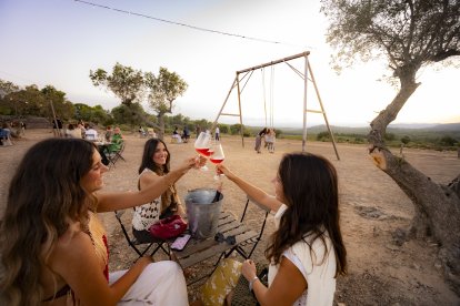 Tres jóvenes brindan en Els Plans by SICUS.