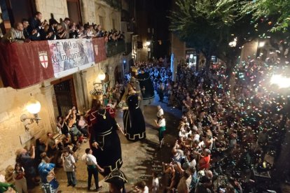 La plaça Major de Montblanc plena de gent, els Gegants ballant i al balcó de l'ajuntament, la pancarta dels 100 anys de l'Amparito ja desplegada.