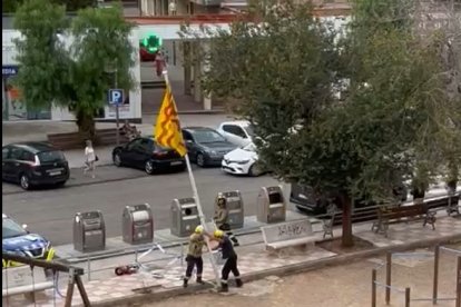 Dos bomberos intentan romper el mástil de la bandera de Tarragona.