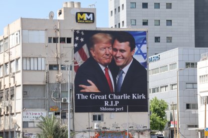 Una valla publicitaria muestra una imagen del presidente de EE. UU., Donald Trump (izq.), abrazando al activista político conservador estadounidense Charlie Kirk para rendir homenaje a Kirk tras su muerte por disparos, en Tel Aviv, Israel, el 12 de septiembre de 2025