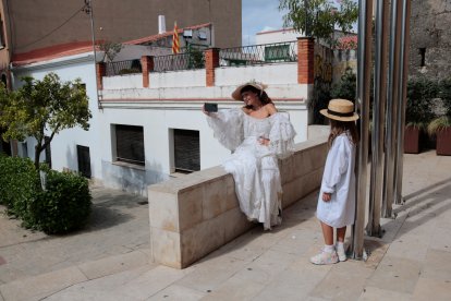 Una dona vestida d'indiana es fotografia a Torredembarra durant la XIV Fira d'Indians