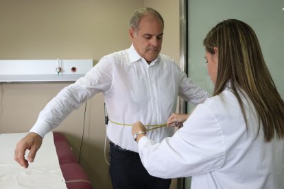 Una nutricionista de Vall d'Hebron mide los perímetros de un paciente que sigue un tratamiento para la obesidad.
