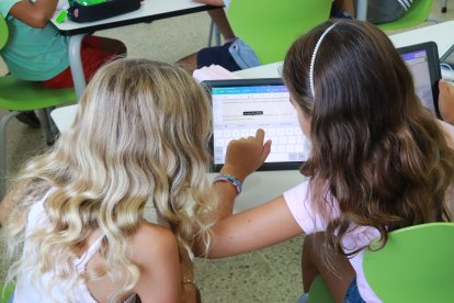 Dos niñas de Primaria trabajan con una tableta en clase.