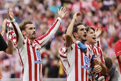 Los jugadores del Atlético de Madrid Antoine Griezmann, Koke y Giuliano saludan al público tras su victoria 5-2 en el partido ante el Real Madrid, este sábado