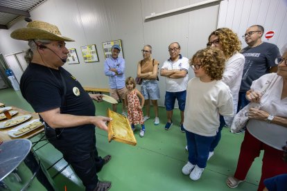 Joan Maria, de Mel el Remei, mostrant bresques als visitants.
