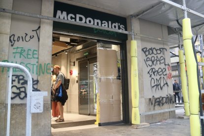 Cartones para cubrir los cristales rotos de la puerta de un establecimiento de comida rápida en La Rambla, Barcelona