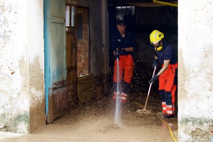 Bombers evacuant aigua en els baixos d'una casa