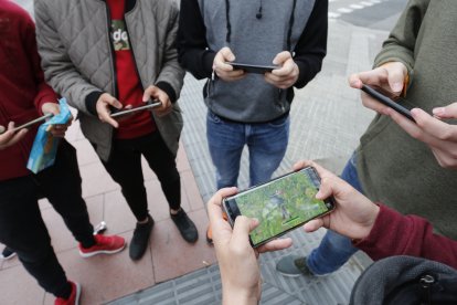 Varios jóvenes de Tarragona juegan a Fortnite en el móvil.