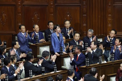 Sanae Takaichi (C) saluda a sus compañeros legisladores tras ser elegida como nueva primera ministra durante la sesión plenaria de una sesión parlamentaria extraordinaria en Tokio