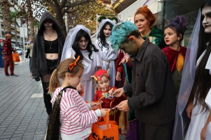 Unos niños recogiendo su recompensa en una tienda de la calle Ciutat de Reus.