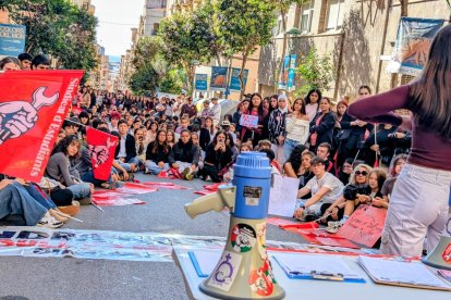 Decenas de estudiantes sentados delante de la sede de Ensenyament.