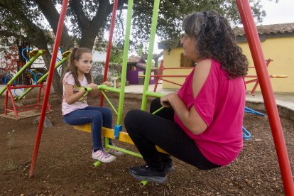 Elsa, de seis años, en el columpio junto a su madre, Roser, después de la operación.