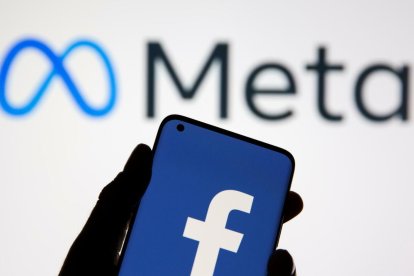 El logo de Meta y un móvil con el logo de Facebook.