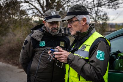 Dos agentes de los Agents Rurals inspeccionan los bosques con ayuda de un dron.