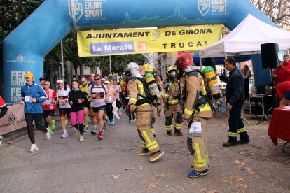 Moment que dues parelles de bombers fan el relleu, a la Mitja Marató de Girona.