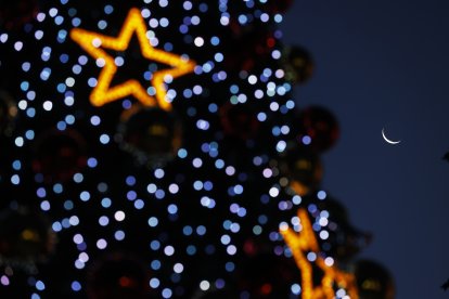 FOTODELDÍA AME190. SANTIAGO (CHILE), 23/12/2025.- Fotografía de la luna junto a luces puestas en un árbol de navidad instalado en el frente de la municipalidad de Providencia este lunes, en Santiago (Chile). EFE/ Elvis González