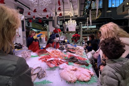 Clientes compran en una parada de pescado del Mercat Central de Reus
