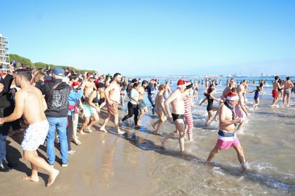 Algunos de los participantes que se han unido al Bany de Sant Silvestre en la playa de La Pineda.
