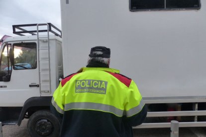Un agente de los Mossos y un camión que participó en la fiesta ilegal de La Sénia.