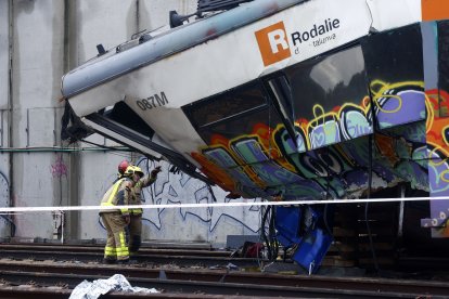 Varios bomberos trabajan en la zona cero del accidente de tren ocurrido el martes en Gelida (Barcelona).